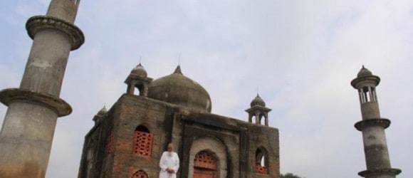 A person in front of a historic brick mosque with minarets under a cloudy sky - Forever Legacy's mausoleums offer luxury, craftsmanship, and lifelong legacy preservation across the USA.