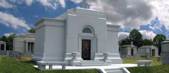 Mausoleum with steps leading to a door adorned with an A